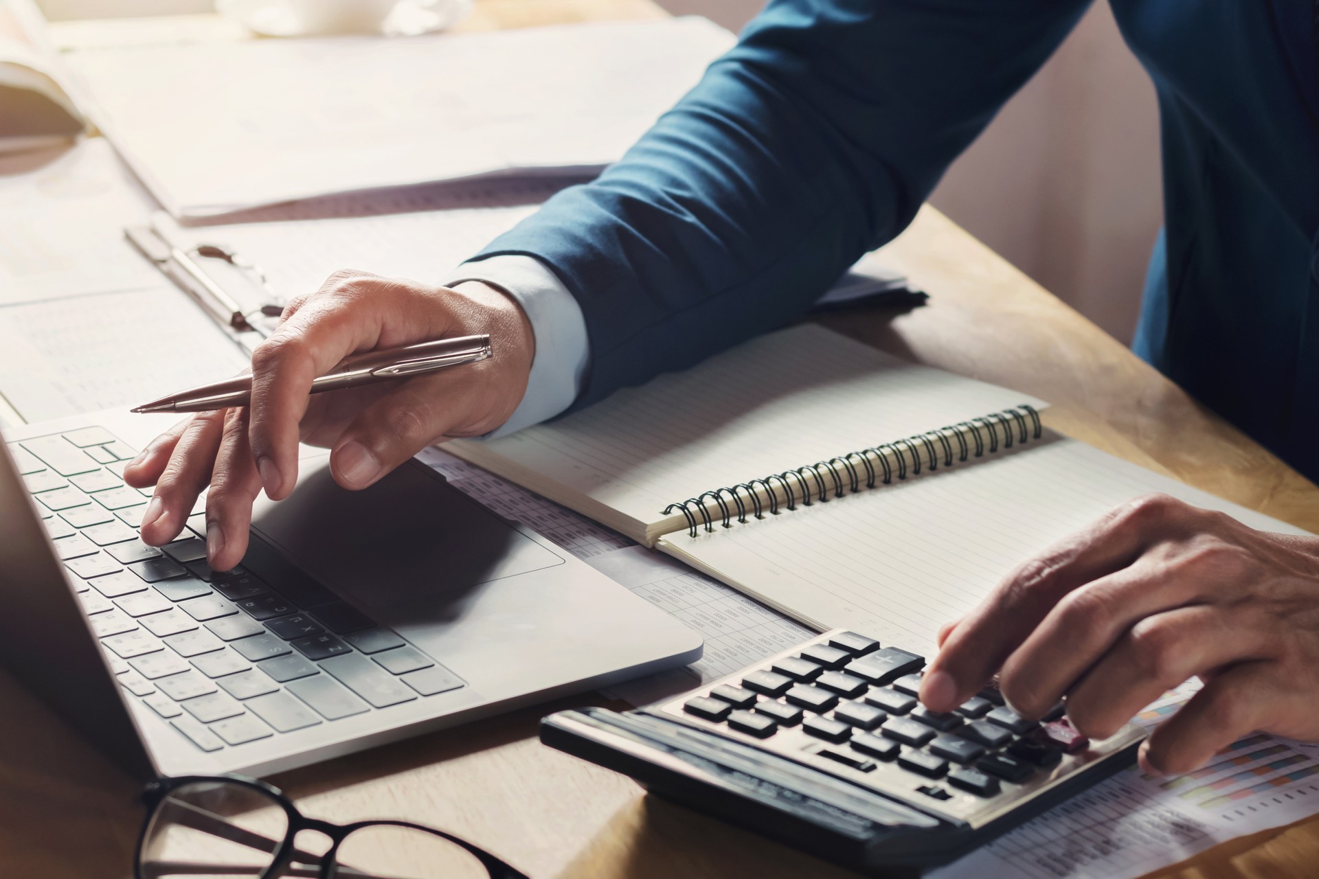 businessman workig and using calculator with laptop on desk businessman workig and using calculator with laptop on desk